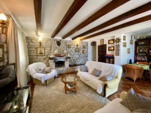 a living room with white furniture and a stone fireplace at House with a pier in Donji Morinj