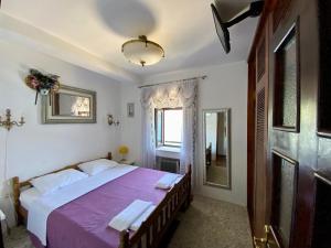 a bedroom with a large bed with a purple blanket at House with a pier in Donji Morinj