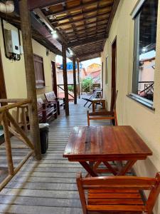a wooden table and two chairs on a porch at Chalés Pulo do Gato in Canoa Quebrada