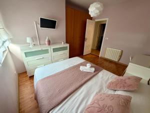 a bedroom with a bed and a dresser and a tv at Piso La Cumbre - CEE in Cee +31 photos