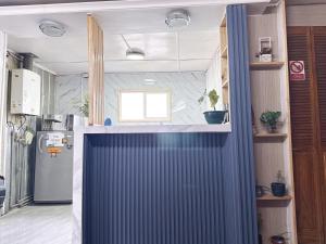 a kitchen with a blue curtain in a room at Hostel 53 Sur in Puerto Natales +51 photos