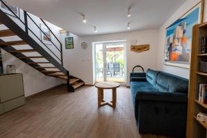 a living room with a couch and a staircase at LU-KA Apartamenty in Swornegacie