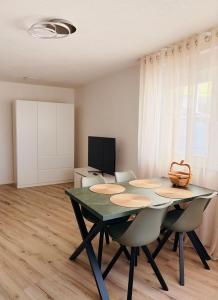 a dining room with a green table and chairs at Darius Apartment Kehl in Kehl am Rhein