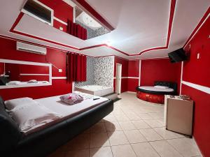 a bedroom with red walls and a bed in a room at Londres hotel thur in Brasília
