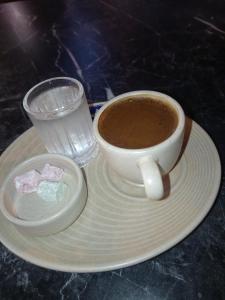 a cup of coffee on a plate next to a glass of water at Egypt holiday in Alexandria