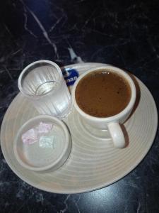 a cup of coffee and a glass of water on a plate at Egypt holiday in Alexandria