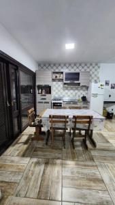 a kitchen with a table and benches in a room at Casa com piscina e próxima ao mar em Imbe in Imbé