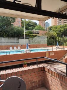 a swimming pool with chairs and a building with a building at Villa del Tesoro in El Poblado