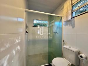 a bathroom with a toilet and a glass shower at Loft em Teresópolis in Teresópolis +2 photos