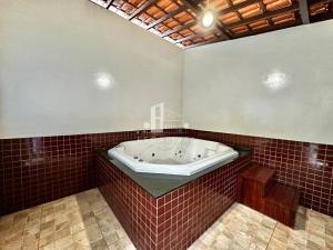 a bath tub in a bathroom with red tiles at Loft em Teresópolis in Teresópolis