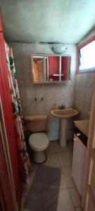 a small bathroom with a toilet and a sink at Cabaña Los Corsarios in El Quisco +27 photos