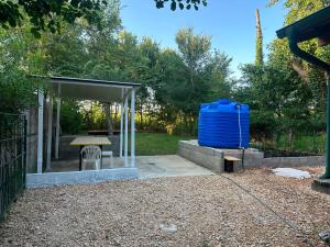 a picnic shelter with a blue water tank in a yard at Bojana Breeze in Ulcinj