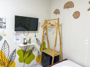 a room with a tv and a chair in a room at Pousada da Sami in Barra de São Miguel