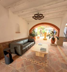 a living room with a leather couch and a table at Casa Sie in Villa de Leyva