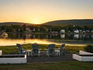a group of chairs and tables in front of a lake at Bailey House Inn - Georgian Waterfront Retreat in Annapolis Royal