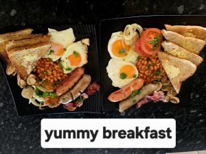 two plates of breakfast food with eggs sausage beans and toast at Peter Country Retreat in Midhirst +6 photos