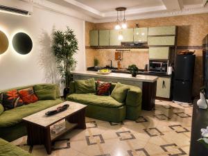 a living room with two couches and a kitchen at Kaz An Nou in Cotonou +4 photos