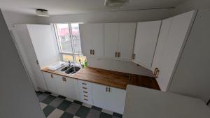 a kitchen with white cabinets and a sink and a window at Sólheimar in Blönduós