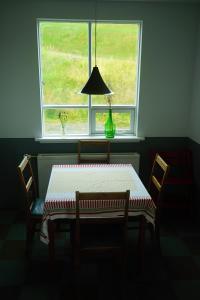 a table and chairs with a window in a room at Sólheimar in Blönduós +11 photos