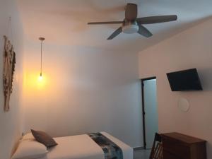 a bedroom with a ceiling fan and a bed at Hotel Boutique Manta in Los Ayala