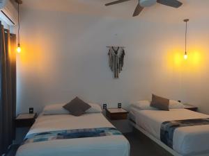 a bedroom with two beds and a ceiling fan at Hotel Boutique Manta in Los Ayala +17 photos