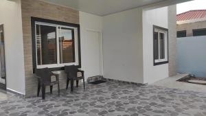 a porch with two chairs and a table in a house at Casa villeda in La Ceiba