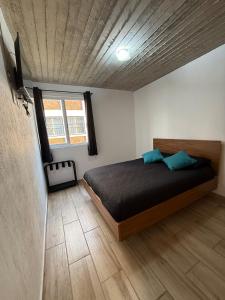 a bedroom with a bed with blue pillows on it at Lovely chalet in Mazamitla in Puente de las Cuevas