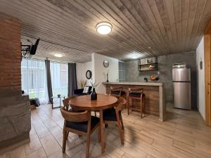 a kitchen and dining room with a table and a refrigerator at Lovely chalet in Mazamitla in Puente de las Cuevas
