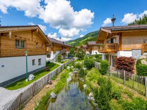 a village with a stream in front of houses at am Teich in Neukirchen am Großvenediger