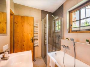 a bathroom with a tub and a shower and a sink at am Teich in Neukirchen am Großvenediger