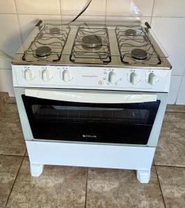 a white stove top oven sitting in a kitchen at Casa Spring in Alfenas