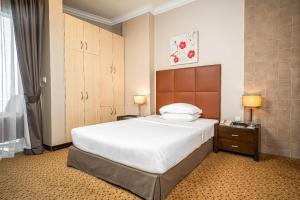 a bedroom with a large bed in a room at Kingsgate Hotel Doha by Millennium Hotels in Doha