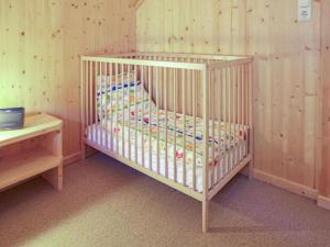 a white crib in a room with wooden walls at Sjenharieja in Stadl an der Mur