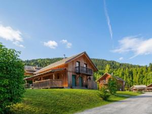a house on a grassy hill with trees in the background at Baier in Stadl an der Mur