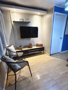 a living room with two chairs and a flat screen tv at Hostel 53 Sur in Puerto Natales