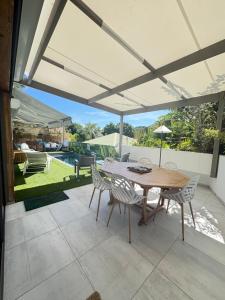 an outdoor patio with a wooden table and chairs at Fully-equipped house with pool in Grande Saline