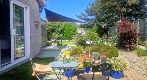 a patio with a table and chairs and plants at Coastal Harmony B&B in Portstewart