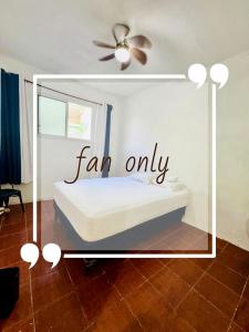 a room with a bed and a ceiling fan at Maple Guest House in Flores +1 photo