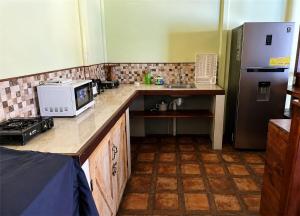 a kitchen with a counter with a microwave and a refrigerator at Ujarrás Getaway with Private Pool in Ujarrás +1 photo