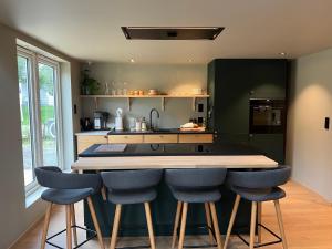 a kitchen with a bar with blue bar stools at The Dream Factory in Andøya
