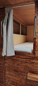 a bunk bed in a room with wooden walls at VNJ Capsule 159 in Hoi An