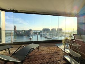 a balcony with chairs and a large window with a view at Bheaven I Captains Apartment in Bremerhaven +7 photos