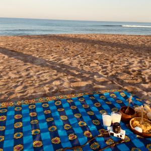 a table on the beach with food and drinks at Beachside Room with Bathroom San Juan ELYU in San Juan