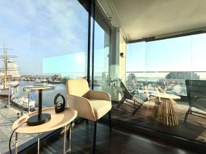 a balcony with chairs and tables and a large window at Bheaven I Captains Apartment in Bremerhaven