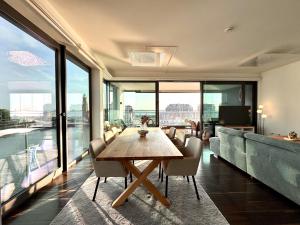 a dining room with a table and chairs and windows at Bheaven I Captains Apartment in Bremerhaven