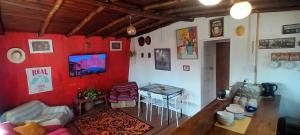 a living room with a table and a red wall at Cabaña Los Corsarios in El Quisco
