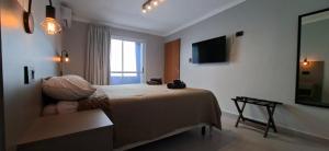 a bedroom with a bed and a television on the wall at Casa Prado in San Fernando del Valle de Catamarca