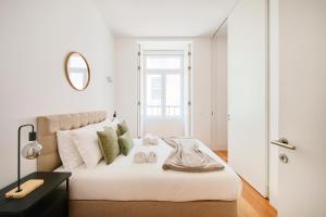a bedroom with a large white bed with a mirror at Casa Portuguesa Ouro in Lisbon