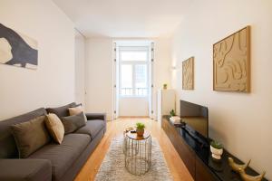 a living room with a couch and a table at Casa Portuguesa Ouro in Lisbon