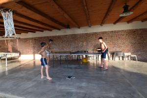 a group of boys playing a game of ping pong at Hotel Marengo in Mina Clavero